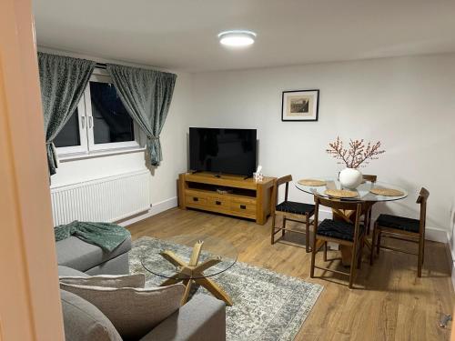 a living room with a tv and a table at Cherry Tree in Oxford