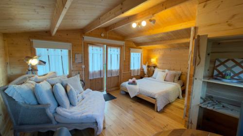 a log cabin bedroom with a bed and a couch at Chalet avec salle d'eau in Chavagne