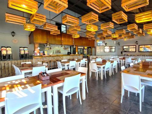ein Restaurant mit Holztischen und weißen Stühlen in der Unterkunft To Strand Holiday Resort in Port Edward