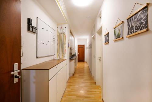 a hallway with white walls and a long hallway with white cabinets at Nest76 in Karlsruhe