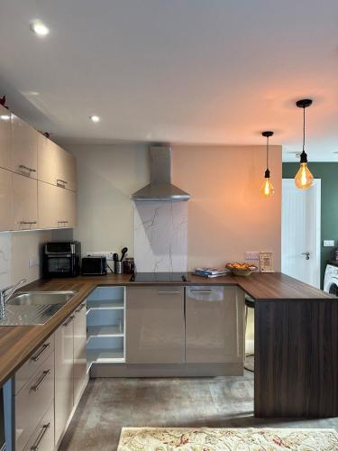 a kitchen with white cabinets and a wooden counter top at The riverside place in Newry