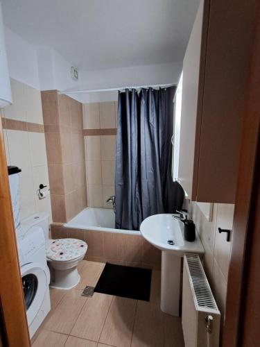 a bathroom with a toilet and a sink and a tub at Endless blue apartment kassandra in Nea Fokea