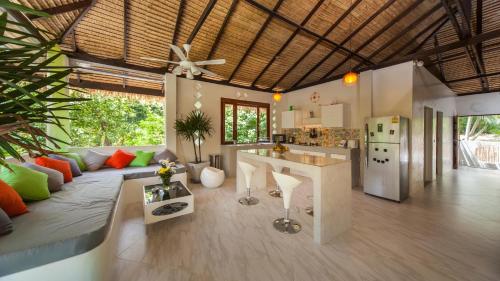 a kitchen and living room with a couch and a table at SandShine Village in Srithanu