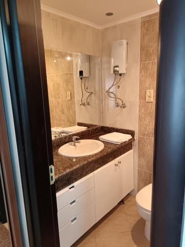 a bathroom with a sink and a toilet at ParadiseHotel in Banī Ghālib