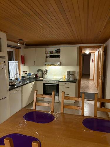eine Küche mit einem Tisch und Stühlen darin in der Unterkunft Midbrekkan Guesthouse in Tvøroyri