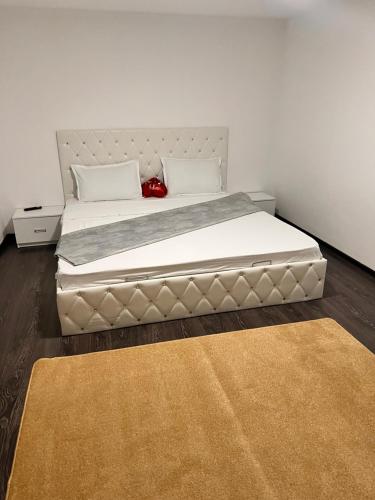 a bed in a bedroom with a white wall at Apartamente B&K in Râşnov