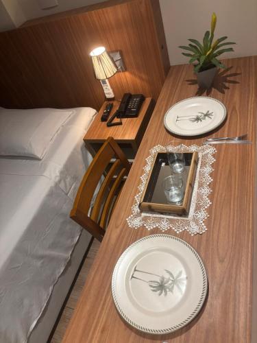 une table avec deux plaques blanches au-dessus dans l'établissement Transamérica Executive Campos dos Goytacazes, à Campos dos Goytacazes