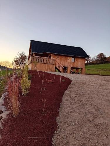 une maison en bois avec un jardin en face dans l'établissement La Cabane de Sophie - Nature et Calme, à Saint-Cernin
