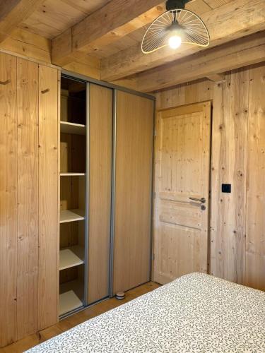 - une chambre avec des murs en bois, un lit et un plafond dans l'établissement La Cabane de Sophie - Nature et Calme, à Saint-Cernin