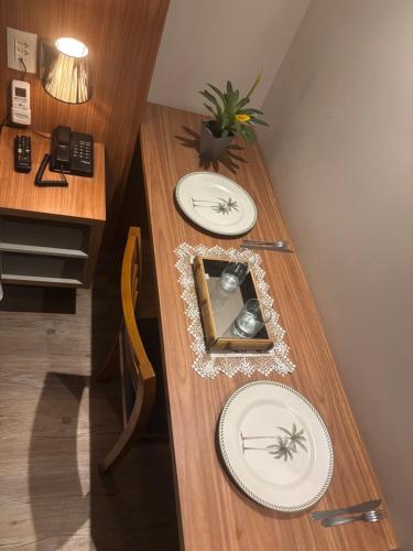 une table avec deux assiettes blanches décorées d'araignées dans l'établissement Transamérica Executive Campos dos Goytacazes, à Campos dos Goytacazes