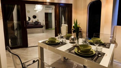 a dining table with green dishes on top of it at SandShine Village in Srithanu