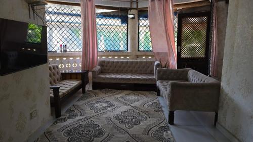 une chambre avec canapés et fenêtres dans un bâtiment dans l'établissement Kivuli Holiday Homes Limited, à Galu