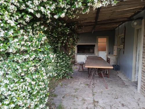 a wooden table and a hedge with white flowers at Quinta "El Ángel Gabriel" in Gowland