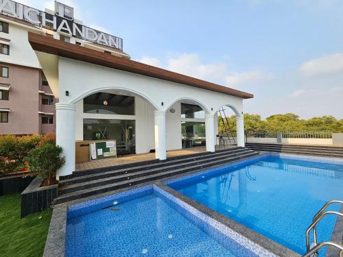 Serene 1BHK Getaway Apartment in Candolim Goa with Pool, Balcony & Kitchen في كاندوليم: حمام سباحة أمام فندق