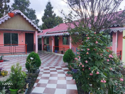 ein rosa Haus mit einem schachbrettartigen Gehweg in der Unterkunft Kanchenjunga home stay in Mangpu