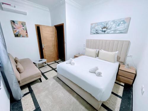 Un dormitorio con una cama blanca y un sofá. en Hotel La Casa Blanca, en Tetuán