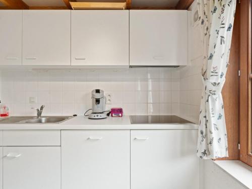 a kitchen with white cabinets and a sink at Zeepark Haerendycke - Vakantiewoning 40 in De Haan