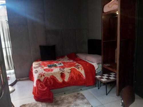 a bedroom with a bed with a red blanket at Loft central in Pelotas