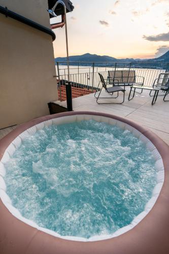a hot tub on a deck with a view of the ocean at DN ART BLEVIO - APT D first floor with lake view terrace and hot tub in Blevio
