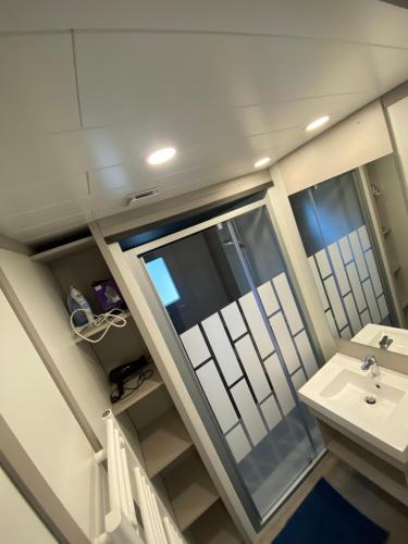 une salle de bain avec un lavabo et un miroir dans l'établissement chalet de l'Edune 6 pers beau standing piscine couverte à 150m de la mer wifi inclus, à Jullouville