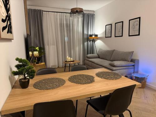 a living room with a wooden table and chairs at W275 Apartment in Pruszków