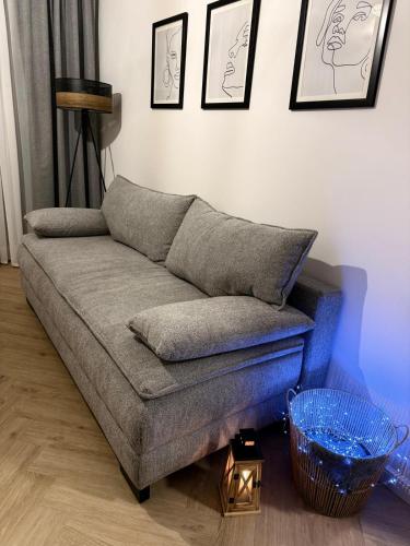 a couch in a living room with pictures on the wall at W275 Apartment in Pruszków
