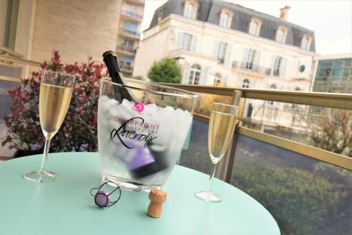 une table avec deux verres et une bouteille de champagne dans l'établissement Le Ray's Inn, à Épernay