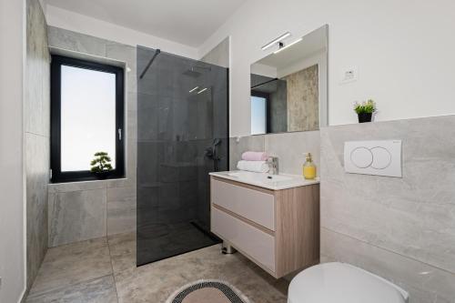 ein Badezimmer mit Waschbecken, Dusche und Toilette in der Unterkunft Santalezi Sunset Villa 2 in Santalezi