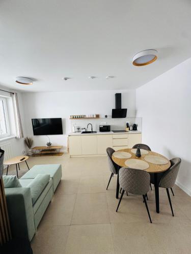 una sala de estar con un sofá, una mesa y sillas en Panorama View Apartment, en Veľký Slavkov