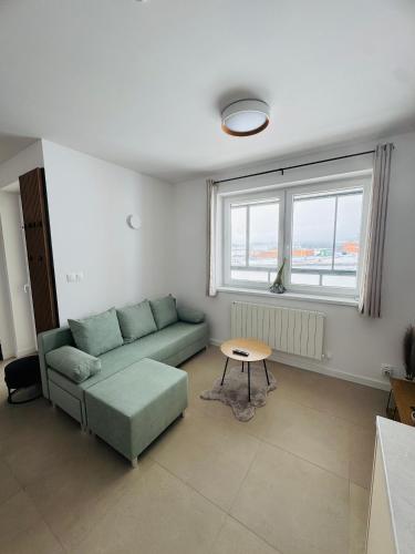 una sala de estar con un sofá y una mesa en Panorama View Apartment, en Veľký Slavkov