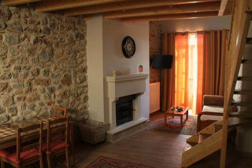 sala de estar con pared de piedra y chimenea en Δρυάδες Suites, en Arachova