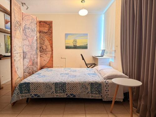 ein kleines Schlafzimmer mit einem Bett und einem Tisch in der Unterkunft Bahia Pelicanos Apartment in Horcon Puchuncavi in Puchuncaví