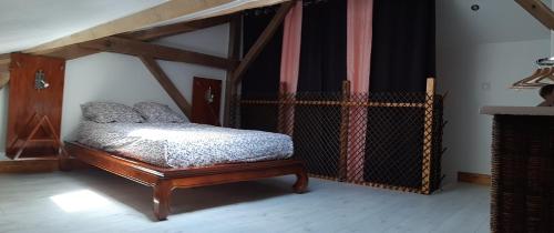 - une chambre avec un lit doté d'un cadre en bois dans l'établissement Gîte, jacuzzi & vin au grenier de Madiran, à Madiran