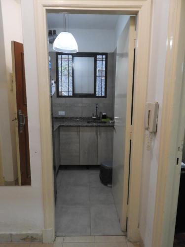 een hal naar een badkamer met een wastafel en een spiegel bij Departamento Centro BA in Buenos Aires