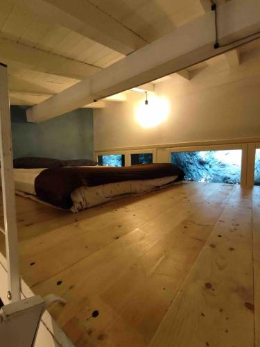 a bed in a room with a wooden floor at NIC Lake House in Sulzano
