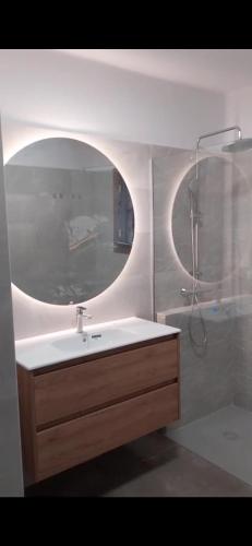 a bathroom with a sink and a mirror at Hogar Palmera with Pool & Beach in Playa Honda