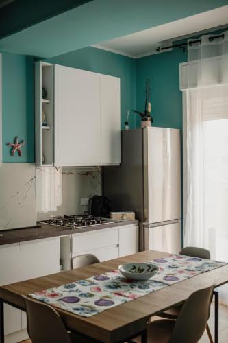 a kitchen with a table and a refrigerator at Sarina's apartment in Palermo