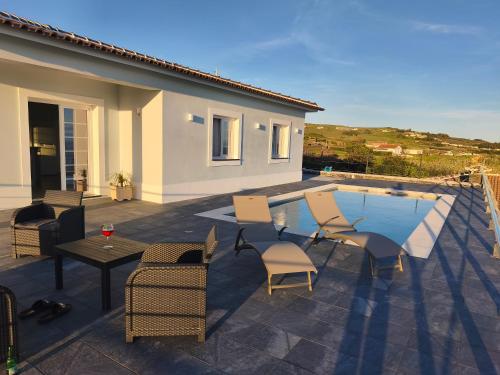 a patio with chairs and a table and a pool at Cantinho do alto in Porto Judeu