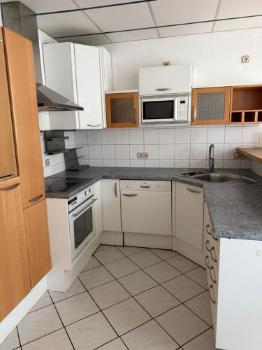 une cuisine avec des armoires blanches et un évier dans l'établissement Monteurzimmer & Monteurwohnung Reichenbach an der Fils, à Reichenbach an der Fils