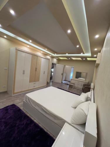 une chambre avec un grand lit blanc dans une pièce dans l'établissement شيراتون للخدمات الفندقيه الفاخره, au Caire