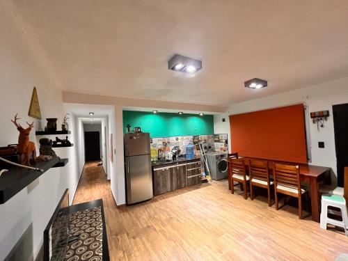 a kitchen and dining room with a green wall at Las Catitas in Villa del Lago