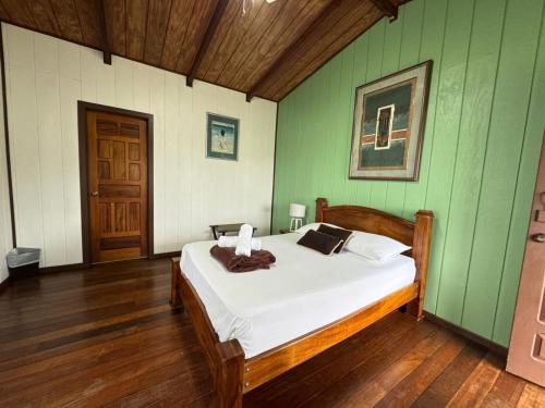 Habitación doble, Hotel Aurora Inn, Nuevo Arenal في نويفو أرينال: غرفة نوم بسرير في جدار أخضر