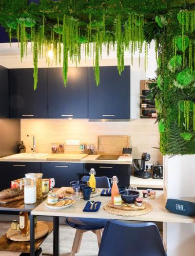 a kitchen with a table with chairs and green plants at Evasion à deux - Spa privatif in Beaugency