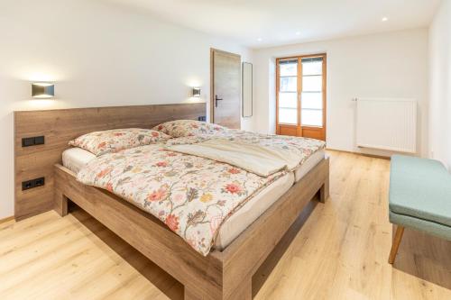 a bedroom with a large bed and a blue chair at Gästehaus zum Thoma in Kreuth