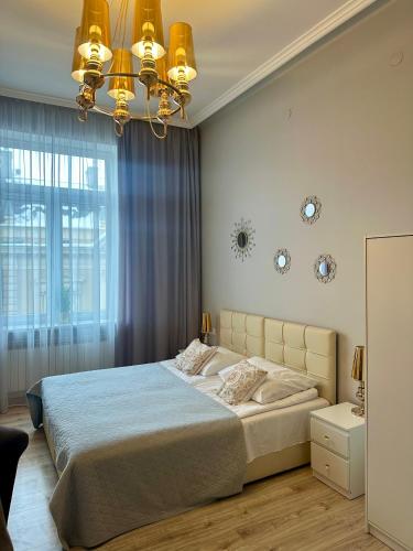 a bedroom with a large bed and a chandelier at Apartament Mickiewicza - PKP Station in Przemyśl