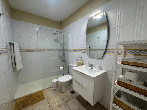 ein Badezimmer mit Waschbecken, Toilette und Spiegel in der Unterkunft Parque Don José 189 in Arona