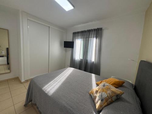 ein Schlafzimmer mit einem Bett und zwei Kissen darauf in der Unterkunft Parque Don José 189 in Arona