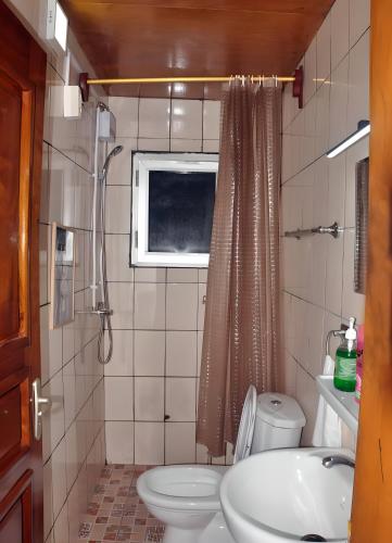 a small bathroom with a toilet and a sink at Petit Nid Douillet à Etoudi in Yaoundé