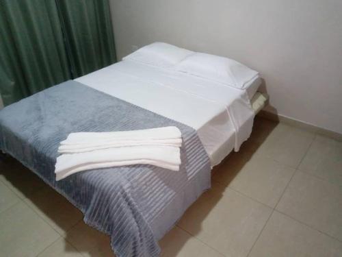 a bed with two white towels on it in a room at Torre Imperial Apartamento in Maracay