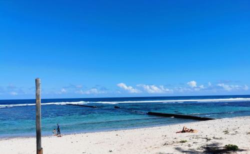 una persona parada en una playa con el océano en Tara, en Saint-Pierre